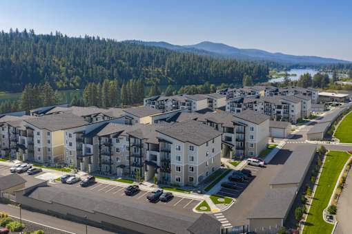 A large apartment complex with a parking lot in front.