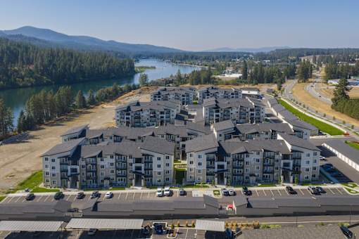 A large apartment complex with a parking lot in front.