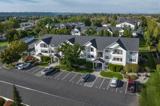 an aerial view of a neighborhood of houses with cars parked in a parking lot