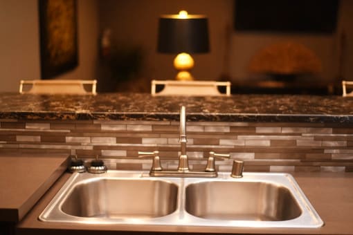 a kitchen sink with a granite counter top