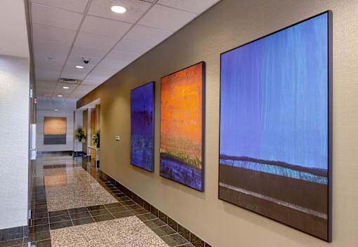 three paintings hanging on a wall in a hallway