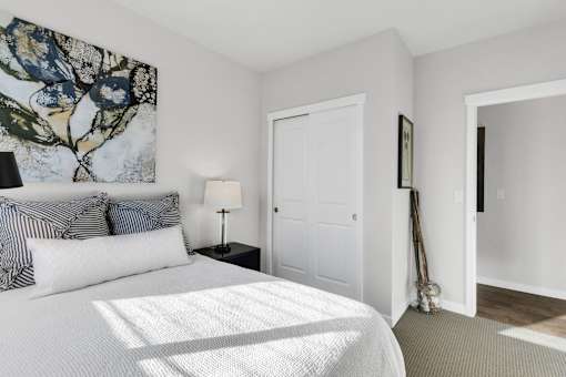 A bedroom with a large bed and a painting on the wall.