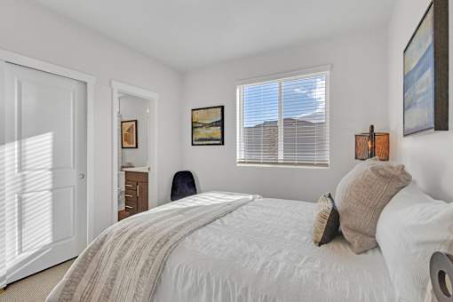 A bedroom with a large bed and a chair.