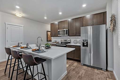 A modern kitchen with a white countertop and a stainless steel refrigerator.