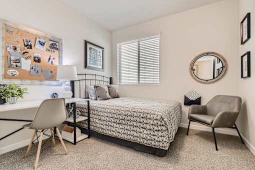 a bedroom with a bed and a desk with a chair