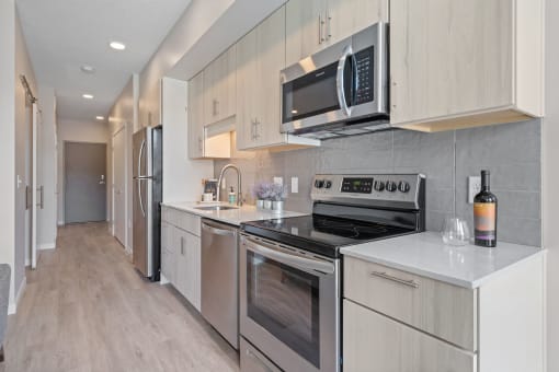 a kitchen with white cabinets and stainless steel appliances