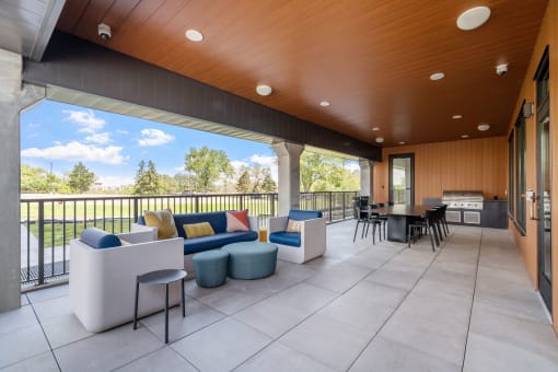 a patio with couches and chairs and a grill