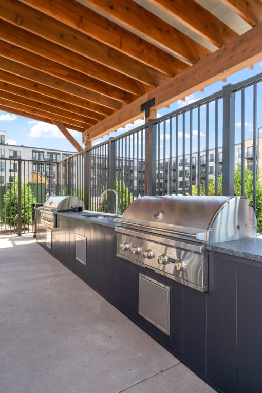 an outdoor kitchen with stainless steel appliances and a wooden roof