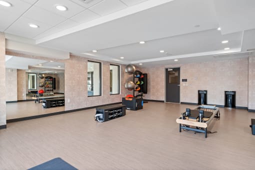 a spacious fitness room with a ping pong table and other exercise equipment