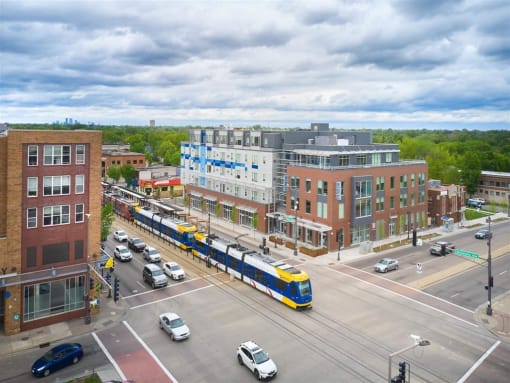 a blue and yellow train traveling through a city