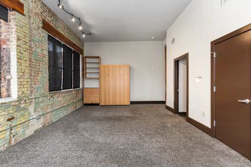 A room with a brick wall and a carpeted floor.