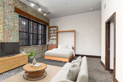 A living room with a brick wall and a television.