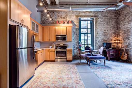 a kitchen with wooden cabinets and stainless steel appliances in a loft