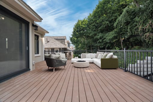 a deck with a couch and a fire pit on it
