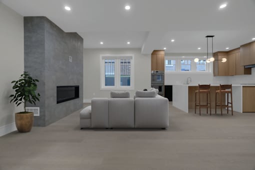 a white living room with a white couch and a kitchen