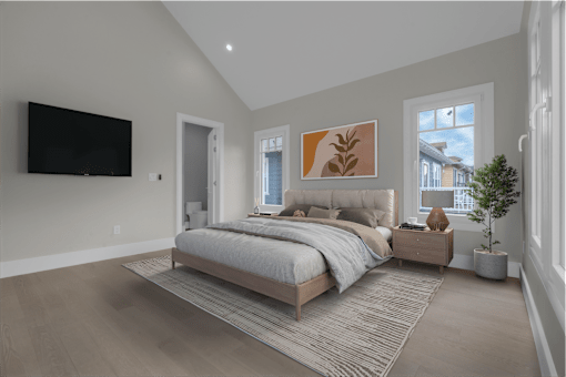 a bedroom with a bed and a tv on the wall