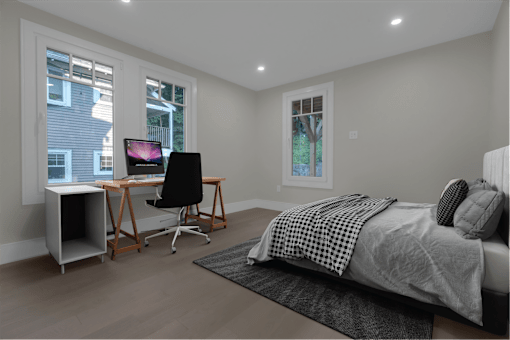 a bedroom with a bed and a desk with a computer