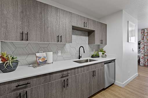a kitchen with white countertops and gray cabinets and a sink