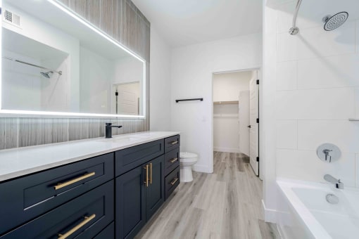 a bathroom with a large mirror and a sink and a toilet