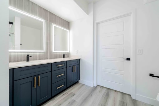 a bathroom with dark blue cabinets and a white door