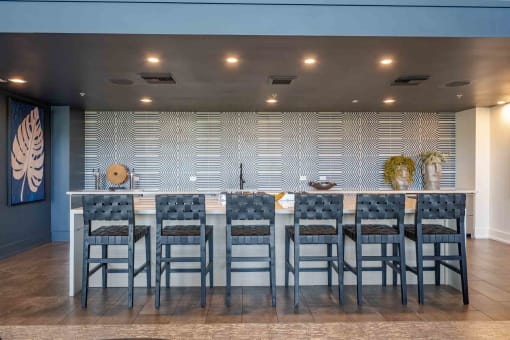 a large table with chairs in front of a wall with a geometric pattern