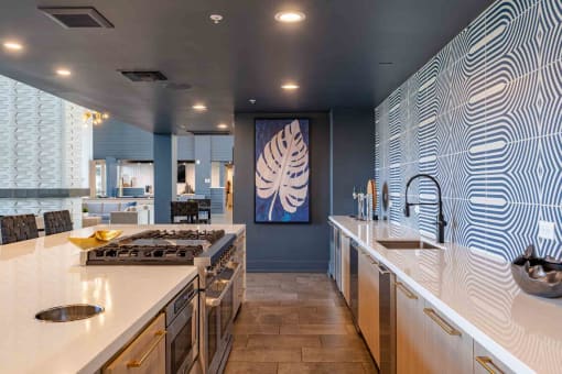 a large kitchen with white countertops and a large painting on the wall