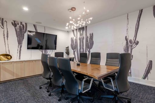 a conference room with a table and chairs and a tv on the wall