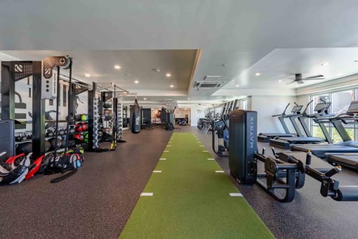 a spacious fitness center with cardio machines and weights