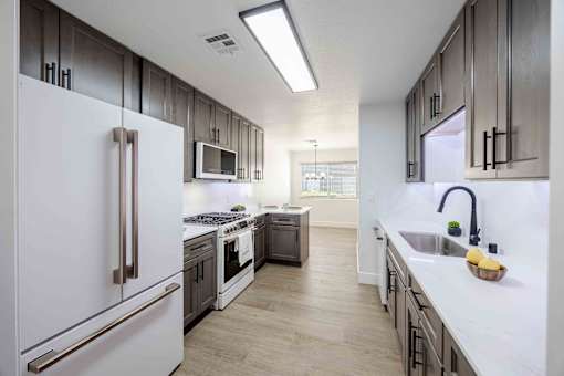 a large kitchen with white appliances and wooden cabinets