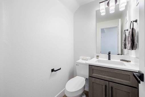 a bathroom with a sink toilet and a mirror
