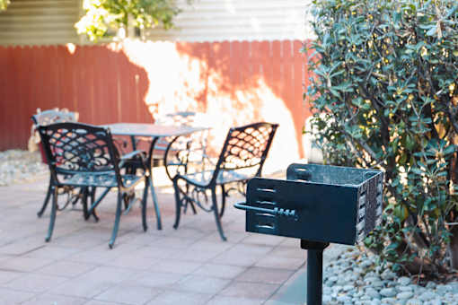 A black mailbox sits on a post in front of a bush at I Street Apartments, Davis, California