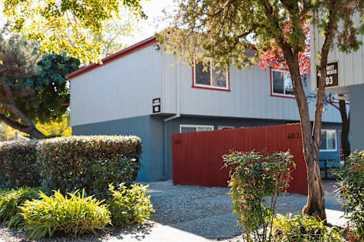 A white and red building with a red garage door at I Street Apartments, Davis, CA 95616