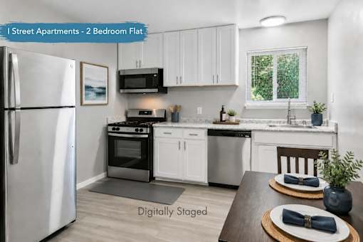 A kitchen with a refrigerator, stove, and sink.