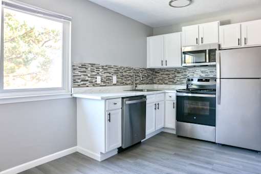 A kitchen with white cabinets and stainless steel appliances.