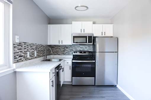 A modern kitchen with stainless steel appliances and white cabinets.
