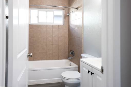 A bathroom with a toilet, sink, and bathtub.