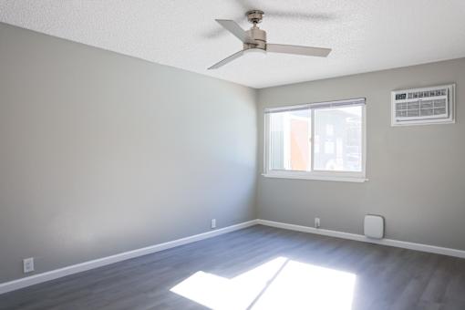 A room with a ceiling fan and a window.