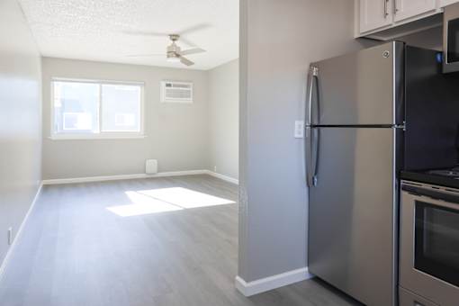 A kitchen with a stainless steel refrigerator and a ceiling fan.