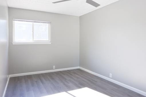 A room with a window and a ceiling fan.