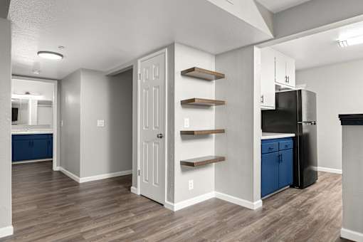 Open layout with wooden shelves and blue cabinetry at Pomona Townhomes Apartments, California, 95928