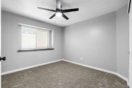 Spacious carpeted bedroom with ceiling fan and deep windowsill at Redwood Cove Apartments, Chico, CA 95928