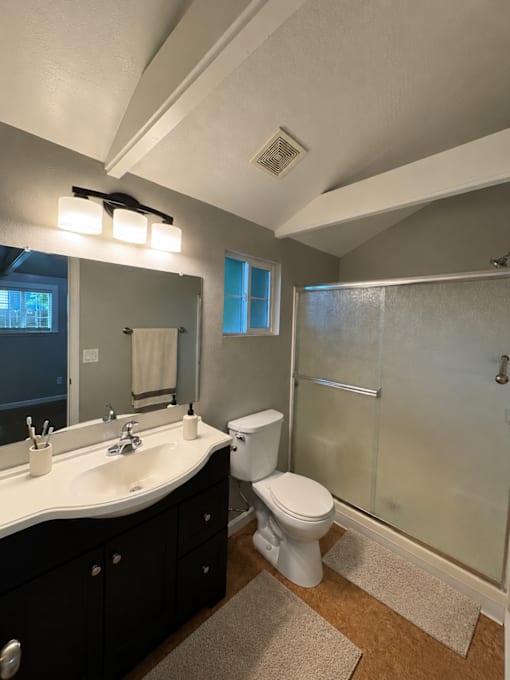 A bathroom with a toilet, sink, and shower.
