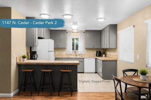 A kitchen with a bar area and a dining table.