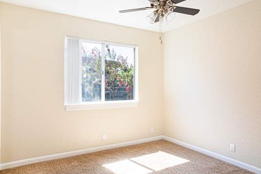 an empty room with a window and a ceiling fan at Creekview Homes, Chico, 95928