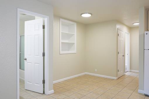 a living room with a white door and a tile floor at Creekview Homes, Chico, California