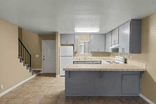 A kitchen with a refrigerator, sink, and cabinets. at Cedar Park Apartments, Chico, 95926