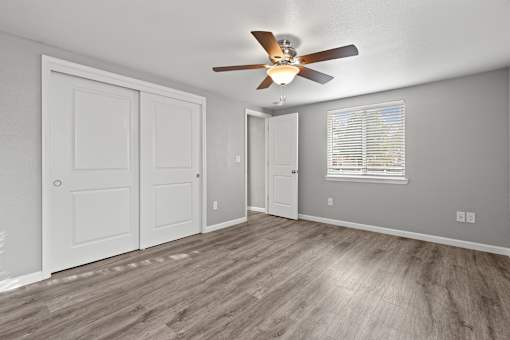 A room with a ceiling fan and wood flooring.at OSM Properties Homes & Apartments, Chico, 95926  