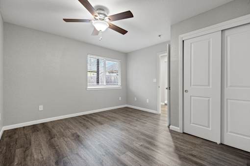 A room with a ceiling fan and wooden flooring.at OSM Properties Homes & Apartments, Chico, CA  