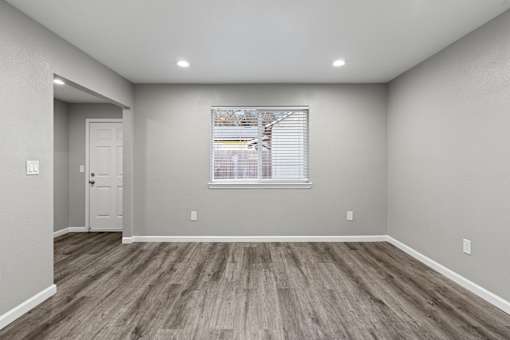 A room with wooden flooring and a window with blinds.at OSM Properties Homes & Apartments, Chico, CA  