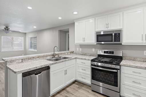 A modern kitchen with white cabinets and stainless steel appliances.at OSM Properties Homes & Apartments, Chico, CA  